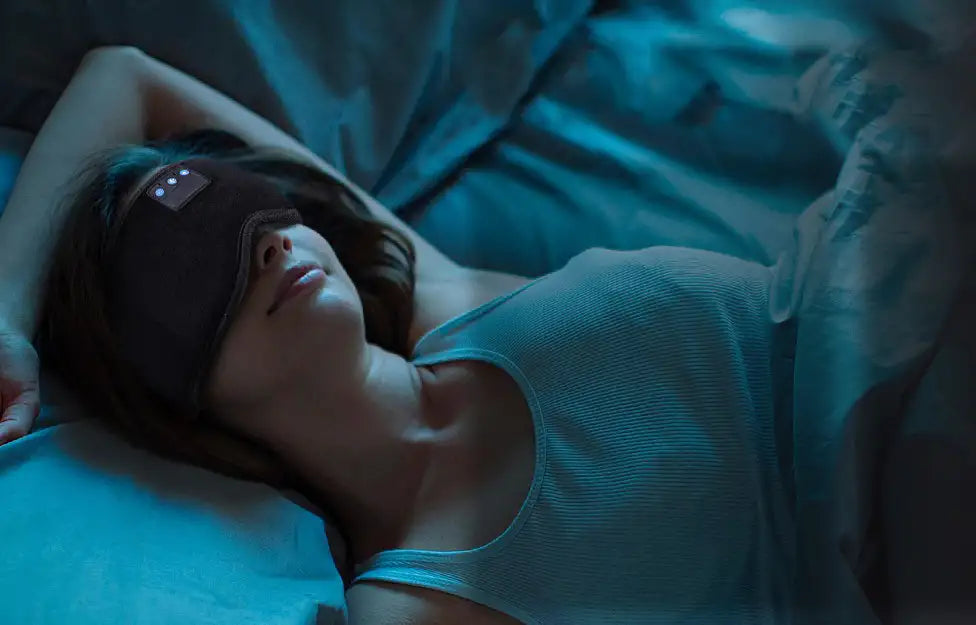 A woman peacefully sleeping in bed while wearing the PRP Bluetooth sleep mask headphones.