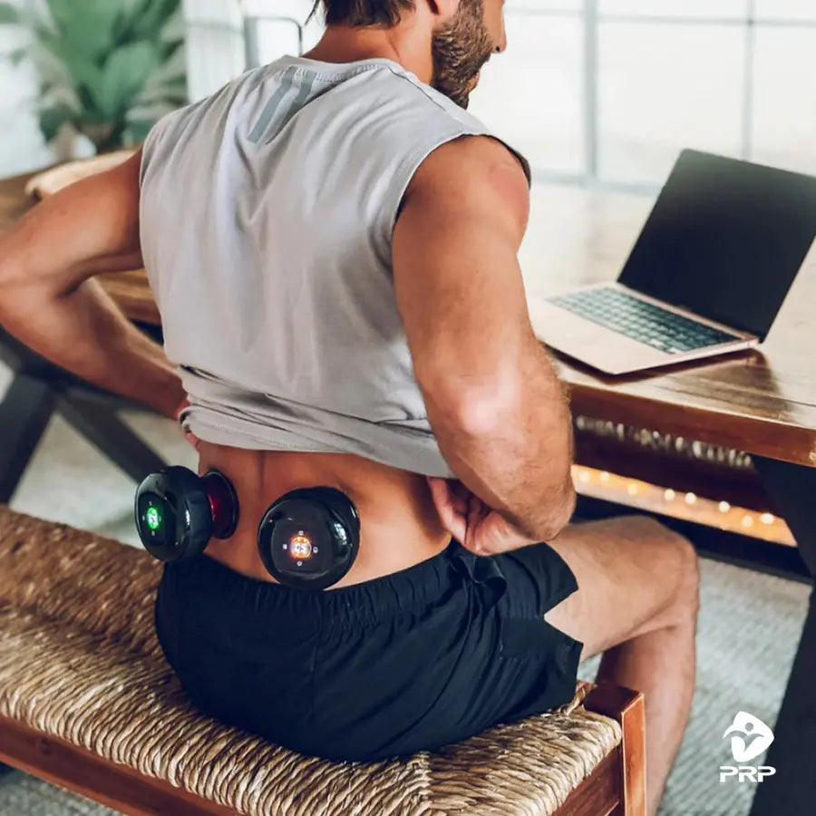 A man using two PRP ThermCup devices on his lower back while sitting, showcasing the simultaneous and easy use of the device.